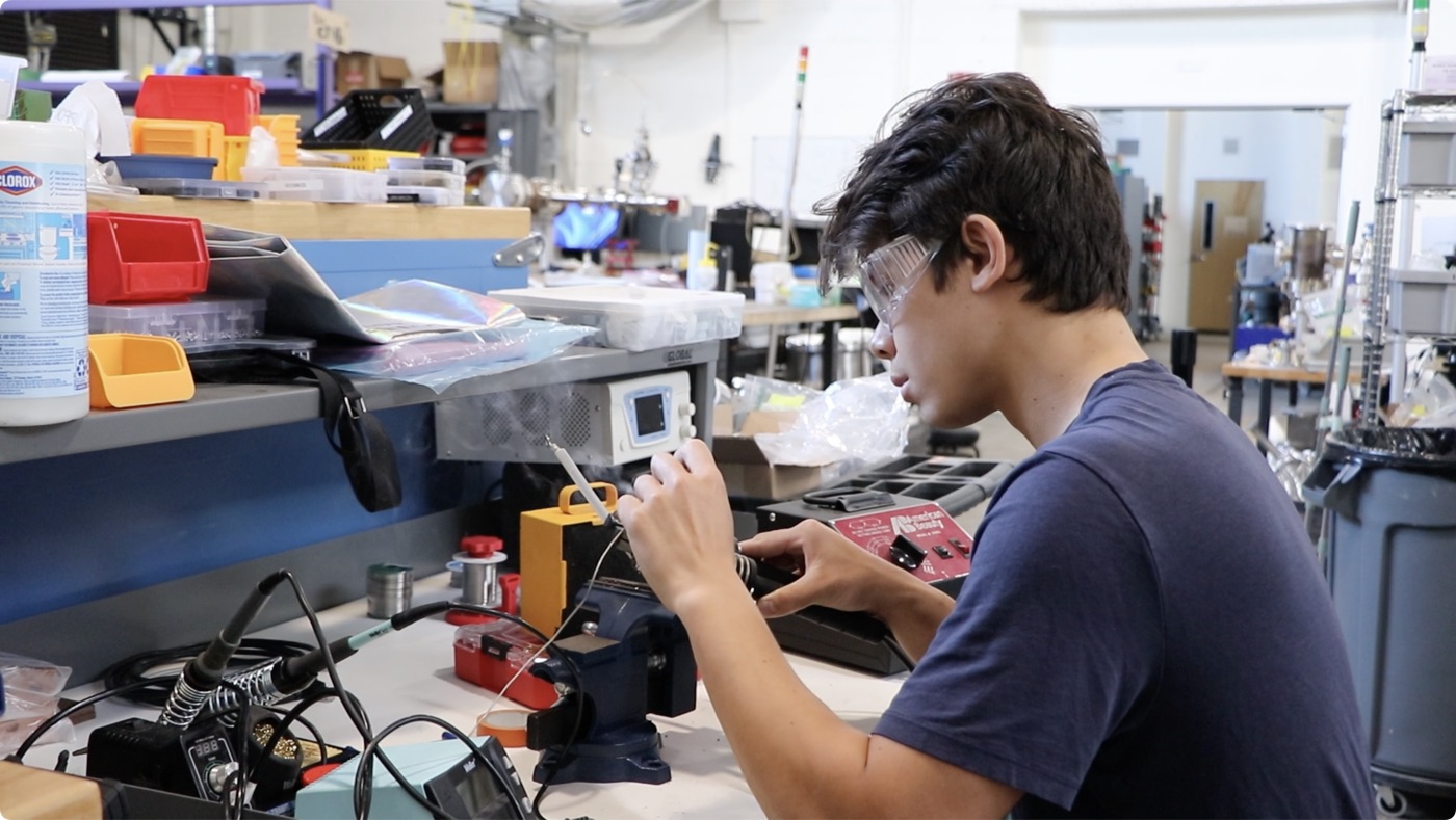 Engineer soldering hardware at the workbench