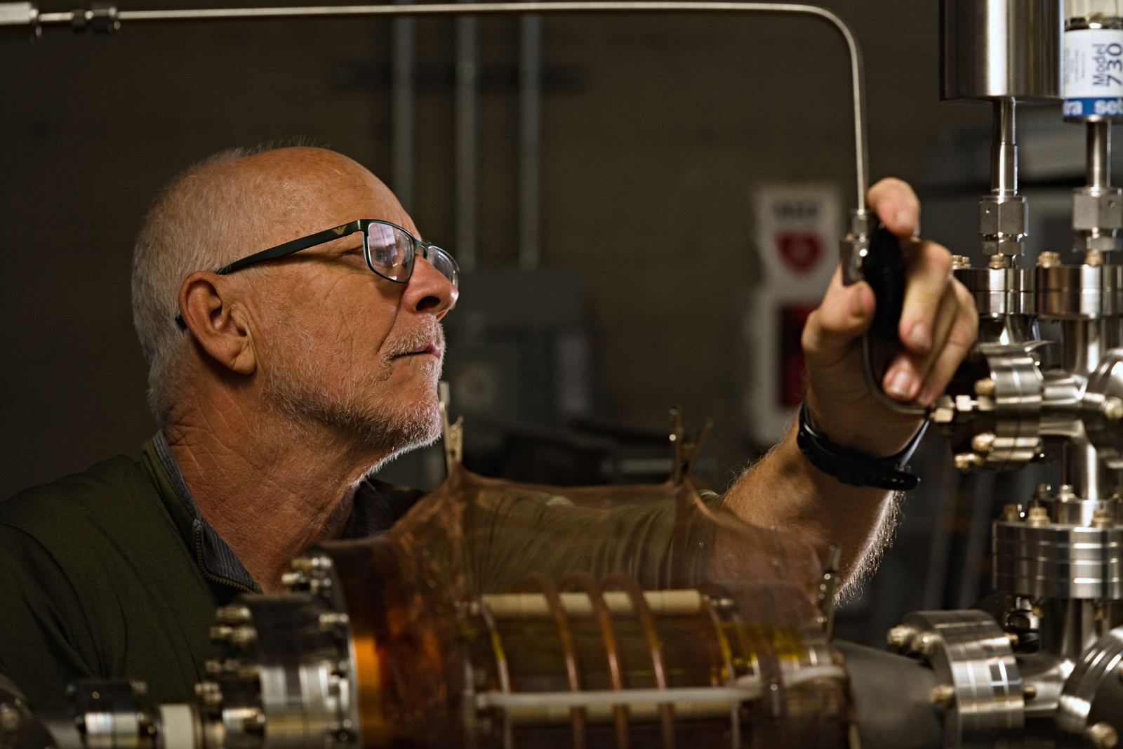Engineer adjusting the ion source vacuum hardware